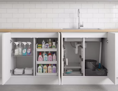 چهار مدل متفاوت نظمدهنده زیر سینک در کابینت واقعی آشپزخانه؛ کشویی استیل ضدزنگ برای بطری اسپری و حولهها، دوطبقه ثابت سفید برای مواد شوینده، قابل تنظیم خاکستری با طراحی انعطافپذیر میان لولهها، و سبد مشکی مشبک ضدزنگ مخصوص وسایل سنگین یا مرطوب.